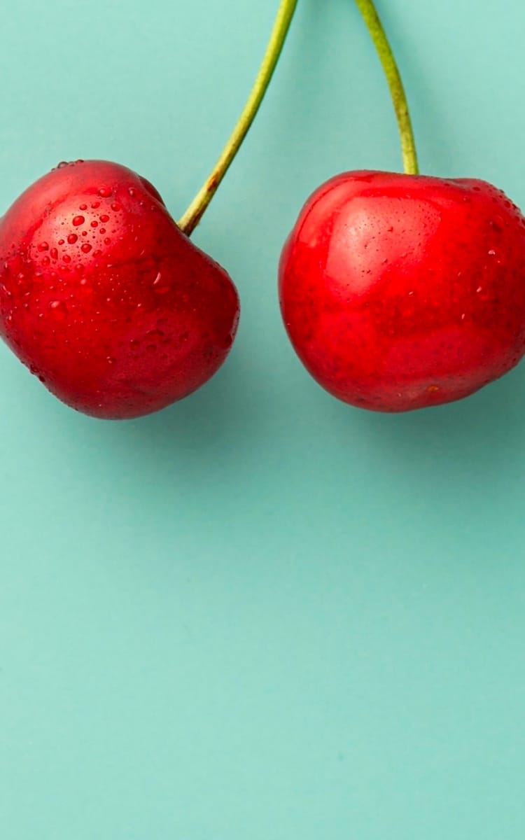 A cherry on a green background.